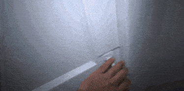 a person 's hand is reaching for a light switch on a white door