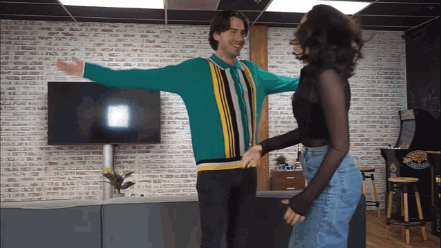 a man in a green sweater is hugging a woman in a black shirt