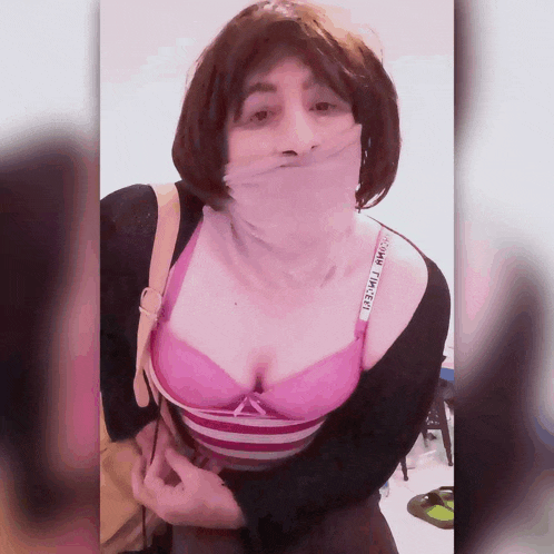 a woman wearing a pink bra with the word victoria 's secret on it