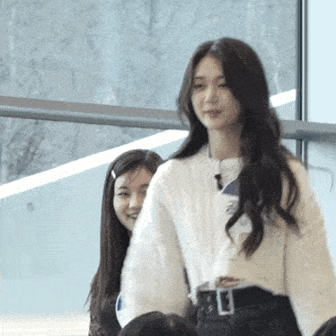 a woman wearing a white sweater has a name tag that says ' i 'm a ' on it