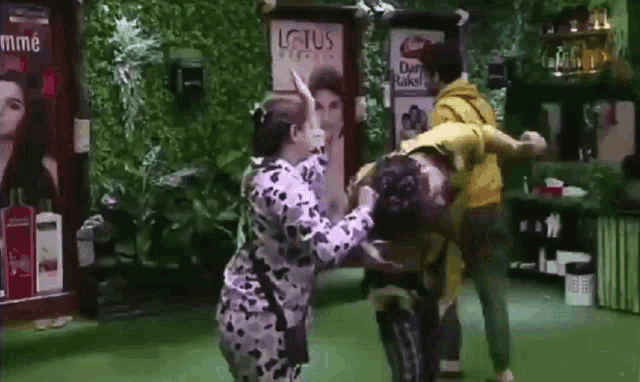 a group of people are fighting in a room with a lotus sign on the wall .
