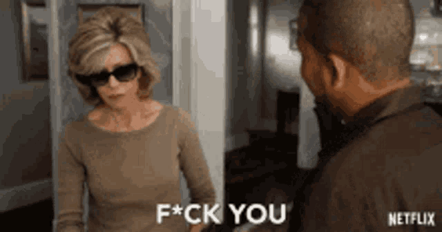 a man and a woman are standing next to each other and the woman is giving the man a f * ck you .
