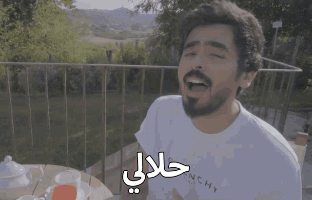 a man with a beard wears a white shirt that says hy