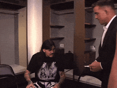 a man wearing a t-shirt that says gis is talking to another man
