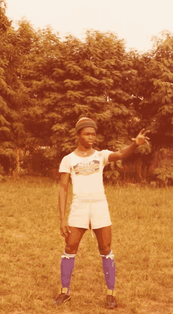a man standing in a field wearing a t-shirt that says cfc on it