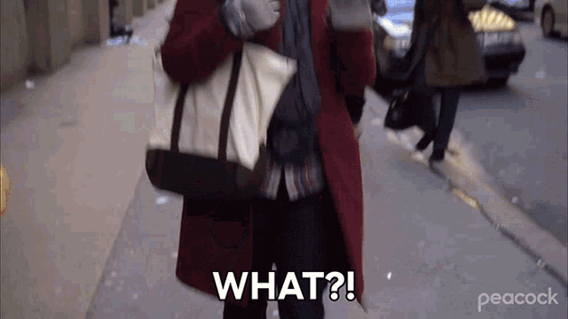 a woman in a red coat is walking down a street and says what ?