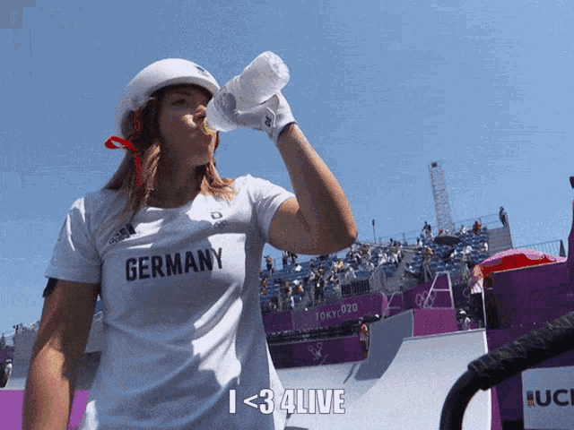 a woman wearing a shirt that says germany is drinking water