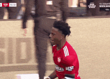 a soccer player in a red jersey that says best on it