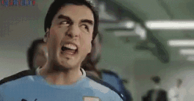 a man in a blue shirt is making a funny face while sitting on a plane .