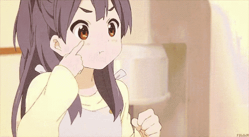 a girl is pointing her finger at her eye .
