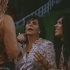 two women are sitting next to each other and one of them is giving a high five .