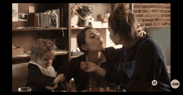 two women and a baby are sitting at a table with a sign that says 10 on it