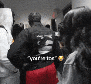 a man in a black jacket says " you 're tos " to a woman
