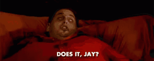 a man in a red shirt is laying on a bed and says does it jay