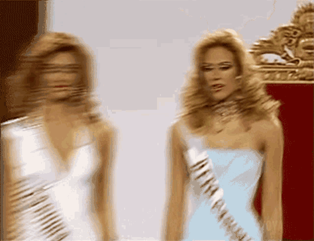 two women are standing next to each other and one has a sash that says america on it