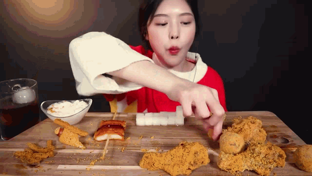 a woman is sitting at a table eating a variety of food