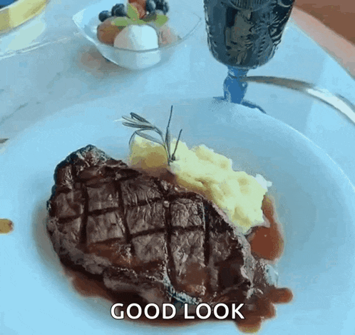 a steak and mashed potatoes on a white plate with the words good look written on the bottom