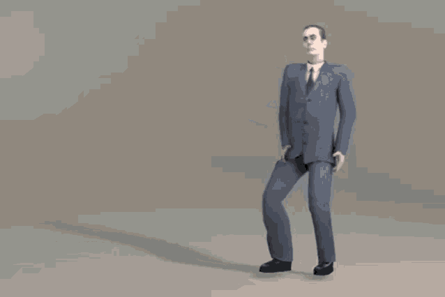a man in a suit and tie is walking on a gray background .