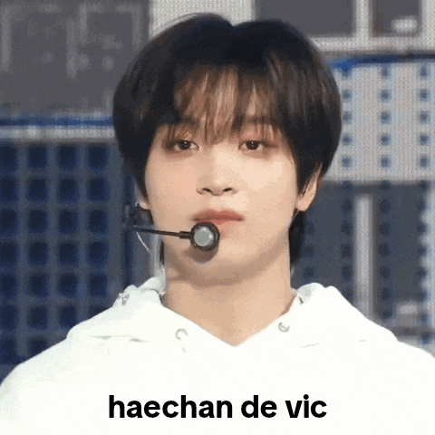 a young man with a microphone in his mouth and the words haechan de vic written below him