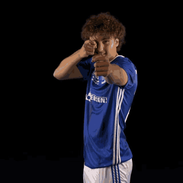 a man wearing a blue shirt with the word lensen on it points at the camera