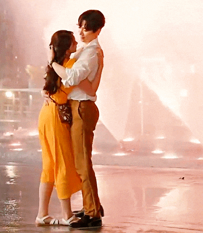 a man and a woman are hugging and kissing on a wet floor