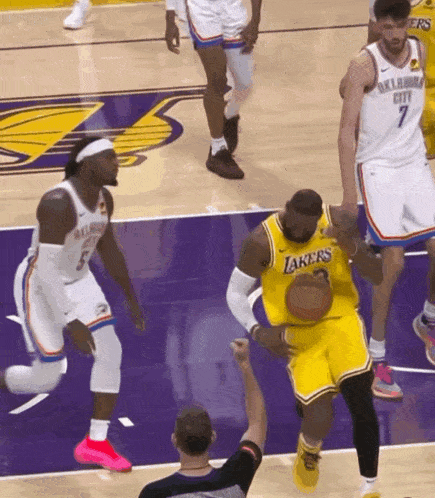 basketball player wearing a lakers jersey dribbles the basketball
