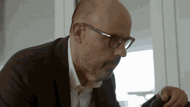 a bald man with glasses and a beard