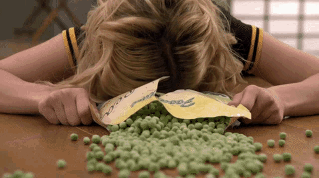 a woman laying on a table with a bag of peas