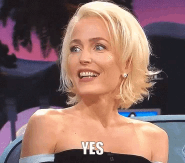 a woman with blonde hair is smiling with the word yes on her face