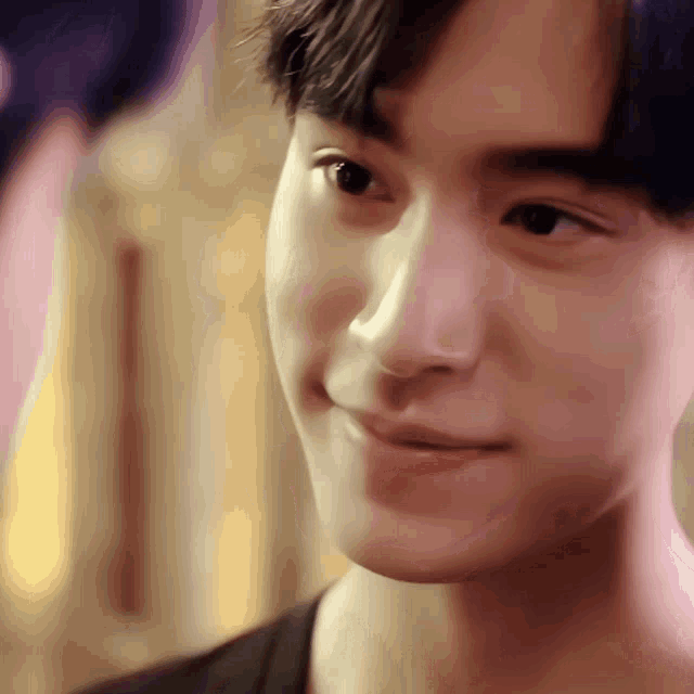 a close up of a young man 's face with a blurred background