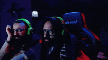 a group of people are sitting in a dark room with glow in the dark headphones .
