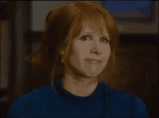 a close up of a woman with red hair making a funny face .