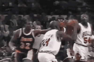a group of basketball players are playing a game .