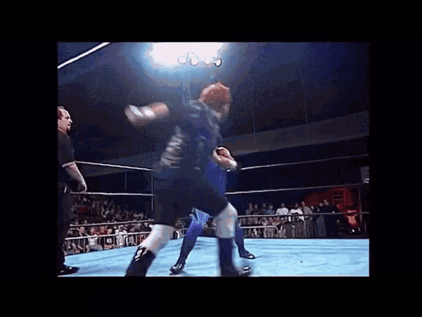 two men are wrestling in a ring and one of them is wearing a shirt that says ' samurai ' on it