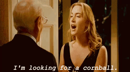 a woman in a black dress is talking to an older man in a suit .