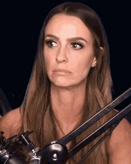 a woman with long hair is sitting in front of a microphone making a funny face .