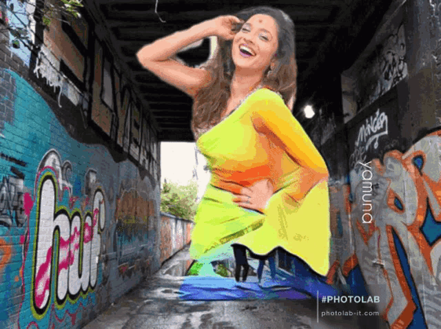 a woman in a yellow dress is standing in a tunnel with graffiti on the wall including the word hai