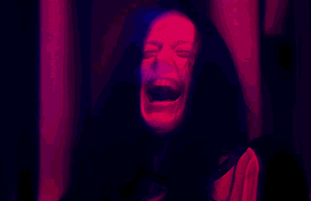 a blurred image of a person 's face with a red and blue background