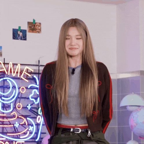 a woman stands in front of a neon sign that says ' ame '