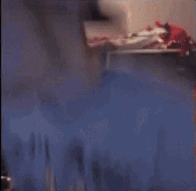a blurry picture of a room with a lot of clothes in it