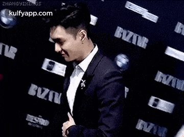 a man in a suit is giving a thumbs up .