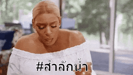 a woman wearing a white off the shoulder top is holding a glass of water .