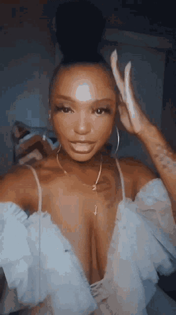 a woman with a bun on her head is wearing a very revealing white dress