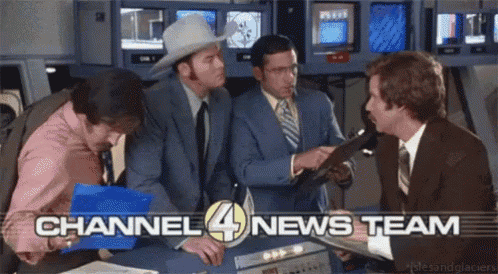 a group of men are gathered around a table with the words channel 4 news team written on it