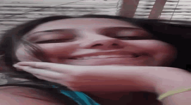 a close up of a woman laying on her stomach with her eyes closed and her hand on her face .