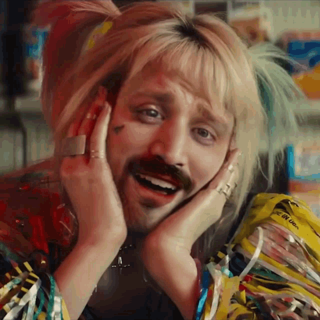a man in a harley quinn costume is making a face with his hands