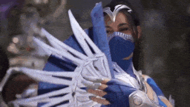 a woman in a costume is holding a fan in her hand .