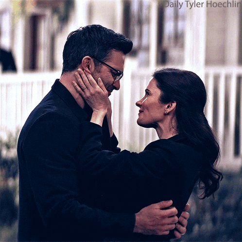 a man and a woman are hugging and looking into each other 's eyes with daily tyler hoechlin in the corner