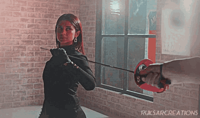 a woman holding a sword in front of a brick wall with ruksarcreations written on the bottom