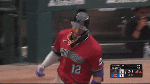 a baseball player in a red jersey with the number 12 on it